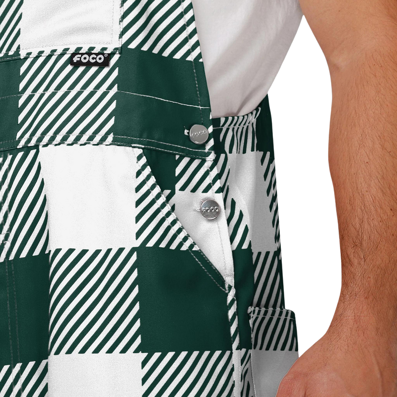 Close up of plaid Michigan State overalls. The colors alternate between green and white. 