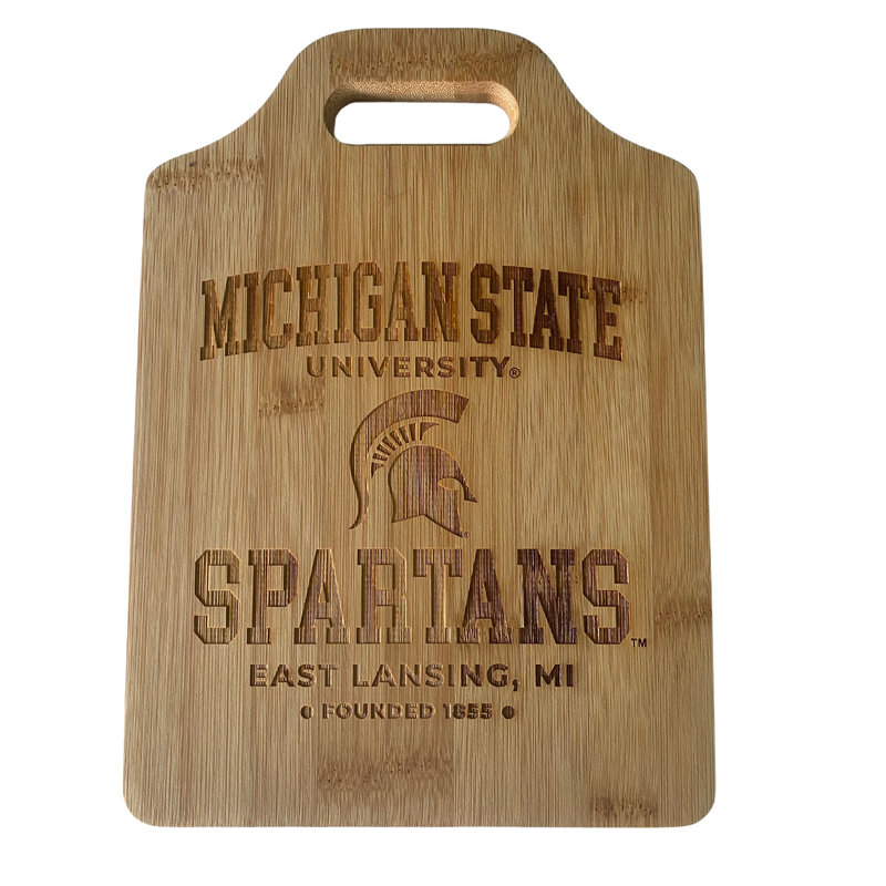 Rectangular wood cutting board with cut-out handle at top, Michigan State University toward top with a Spartan helmet underneath, Spartans below the helmet, East Lansing, MI below Spartans, and founded 1855 at bottom. Imprint is laser engraved.
