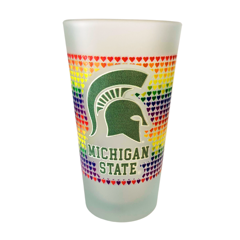 Frosted pint glass with colorful hearts to symbolize Pride, outlining a green Spartan helmet with Michigan State underneath.