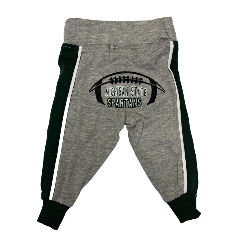 The back side of grey infant sweatpants with green lines going down the side of the pant legs. In the bottom area is the outline of a football with Michigan State Spartans written in the middle. 
