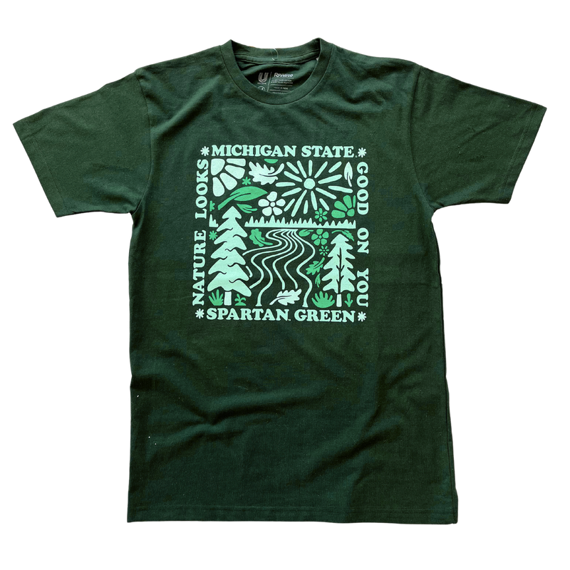 Green t-shirt with Michigan State in light green block lettering on the front, with a partial sun image on the left of the lettering with a leaf on the right. On the back is a large square -shaped nature image with Michigan State on the top, "Nature Looks" on the left and "Good On You" on the right with "Spartan Green" on the bottom.