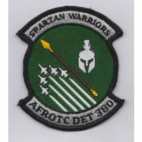 AFROTC detachment 380 logo of 5 fighter jets, a spear, and a spartan helmet in a green circle. Silver bars jut out on the top and bottom reading Spartan Warriors and AFROTC DET 380, respectively
