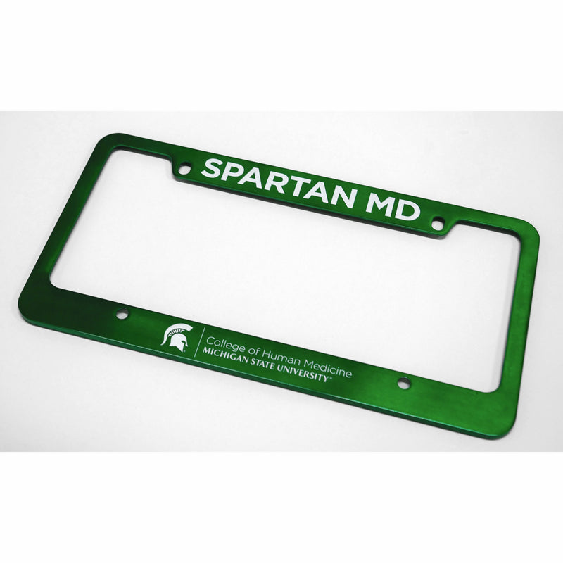 Green license plate frame with four screw tabs. Bold white text reads "Spartan MD" in all caps along top. Bottom has white College of Human Medicine signature logo