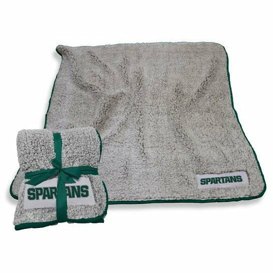 Light grayish beige sherpa blanket with a green piped edge. In the bottom right corner, a white applique reads Spartans in dark green. The blanket comes folded in a square with a green gift ribbon.