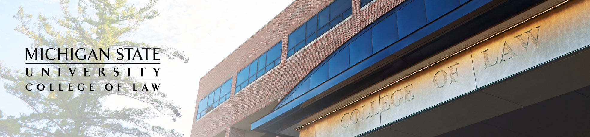 MSU College of Law building entrance photographed on a summer afternoon. The wordmark logo is on the left-hand side.