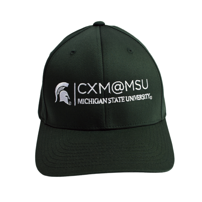 Front of a green baseball cap embroidered with the CXM@MSU signature logo in white.