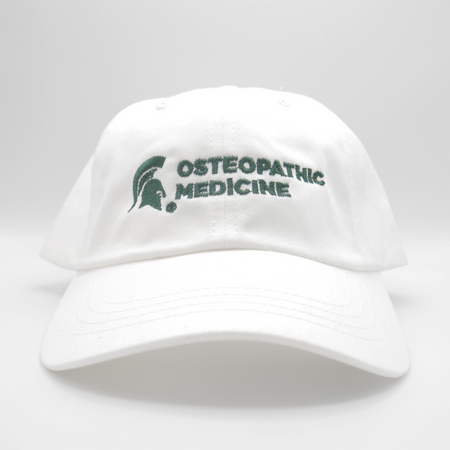 A white ball-cap style hat with a green MSU spartan helmet logo and the words Osteopathic Medicine on the front of the hat. 