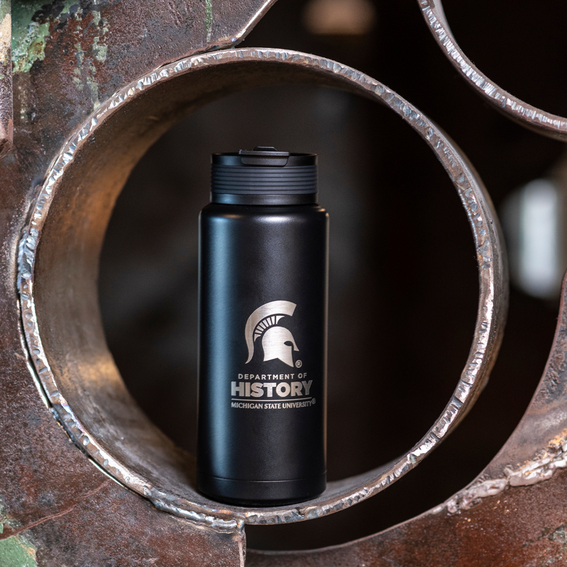 Black 34oz water bottle with a laser-etched design featuring the Department of History logo and Spartan helmet photographed on a metal sculpture. 