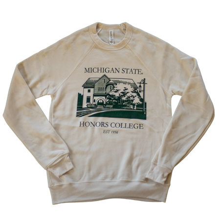 A natural/tan colored crewneck sweatshirt. On the torso of the sweatshirt in green is an image of the first MSU honors college building. Around the image is the text "Michigan State Honors College est. 1956."