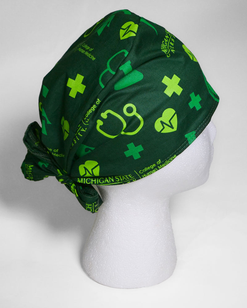 Forest green scrub cap on foam display head. Features lime green and kelly green medical icons all over print. Back tie. 