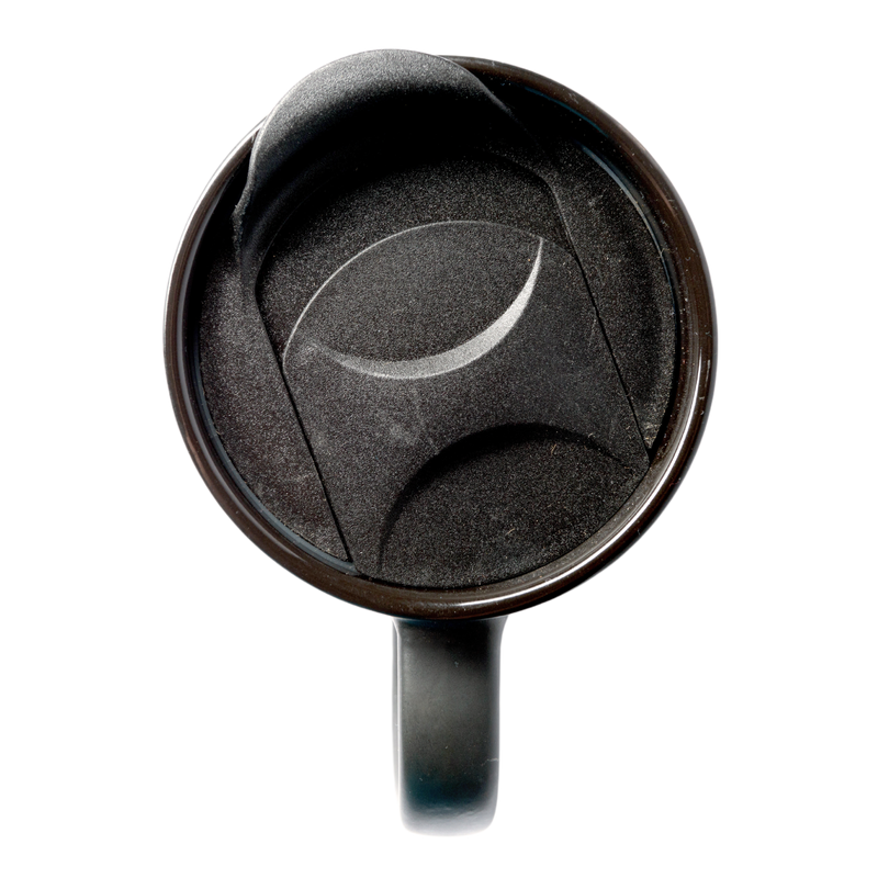 A black travel coffee mug lid sitting on top of a coffee mug.