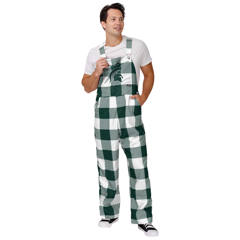 A person wearing plaid Michigan State overalls. The colors alternate between green and white. In the center torso is a green MSU helmet logo.
