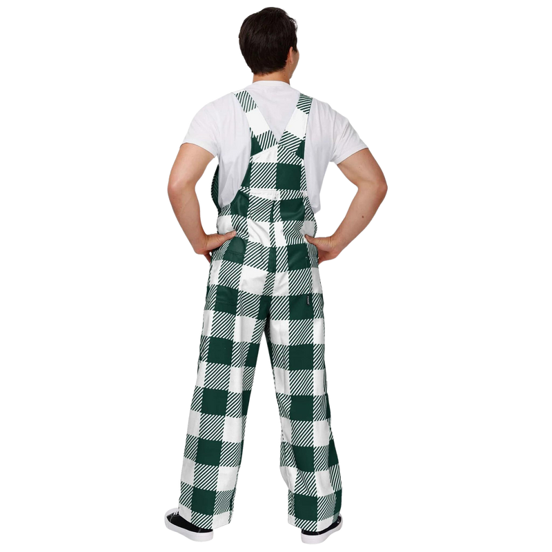 The back of the person wearing plaid Michigan State overalls. The colors alternate between green and white. In the center torso is a green MSU helmet logo.