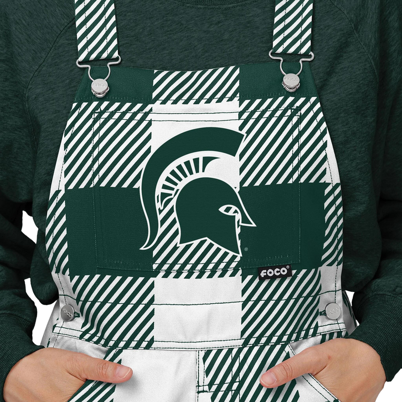 Close up of plaid Michigan State overalls. The colors alternate between green and white. In the center torso is a green MSU helmet logo.