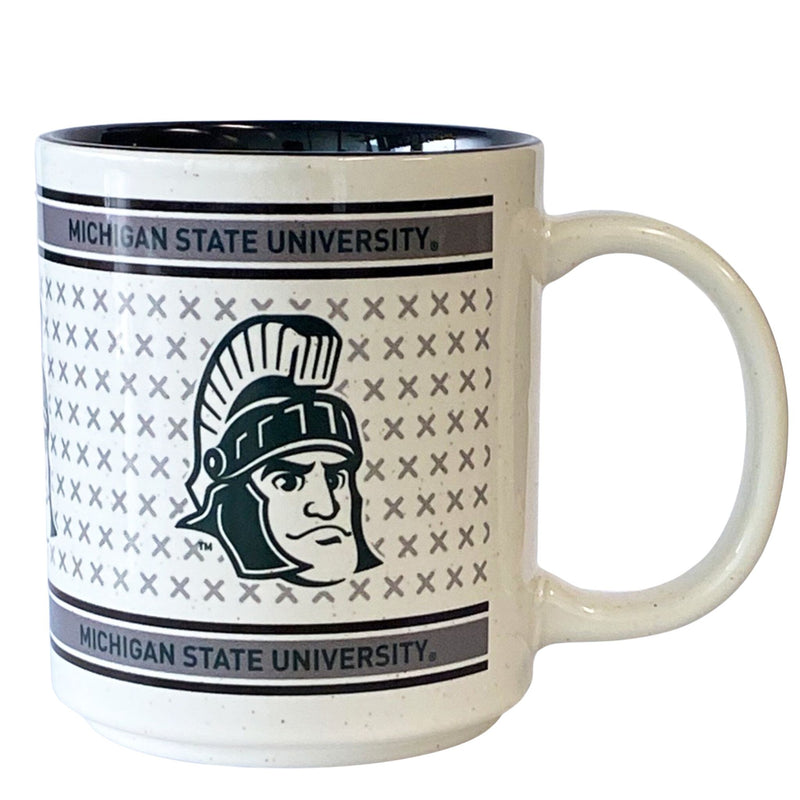 A glossy, cream-colored mug with a soft speckle pattern. Dark green bars across the top and bottom of the design ready "Michigan State University" in black font. In the middle is a pattern of soft green Xs with a dark green Sparty mascot head overlaid. The mug has a curved handle and a glossy black inside.