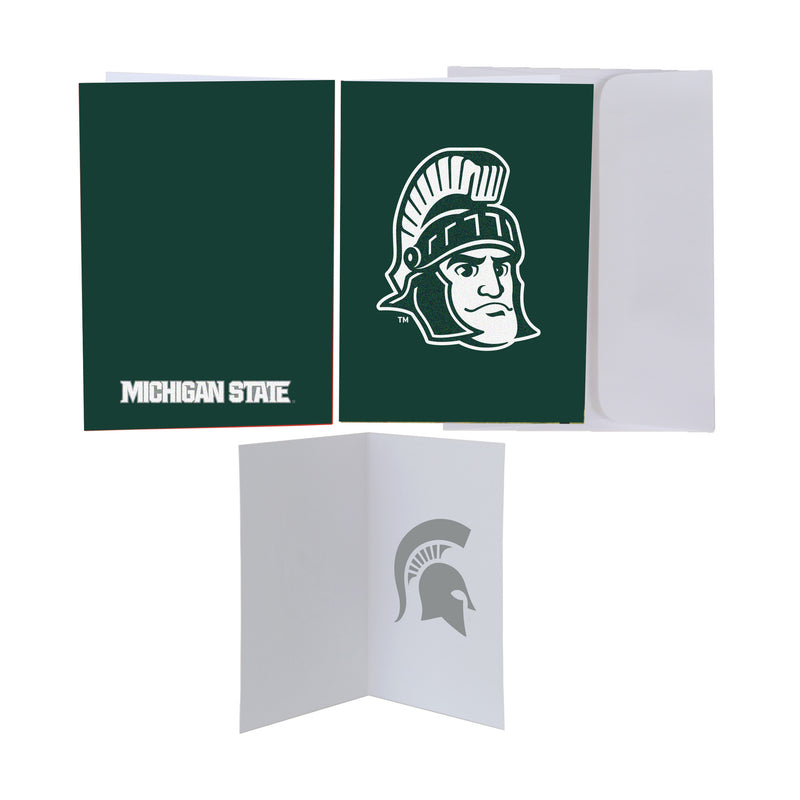Three views of the Sparty greeting card. The front is dark green with Sparty's face shown large in white, with a white envelope tucked behind it. The back is dark green with the words "Michigan State" in white at the bottom. The inside of the card is white with a faint green Spartan helmet watermark on the right side.