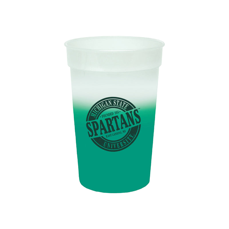 Plastic cup that is green at the bottom and gradually fades to white at the top. Features Michigan State University in outer circle and Spartans in the middle in dark green.