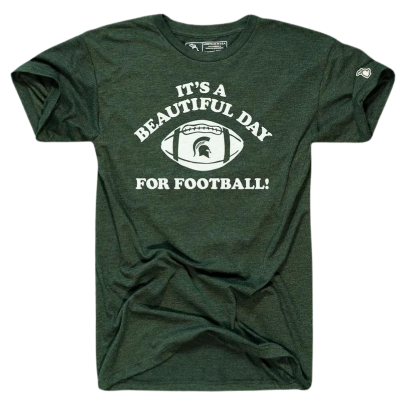 A green tee shirt with white text reading "It's a beautiful day for football" in the center torso. Between the text is a graphic of a football with the MSU spartan helmet logo. 