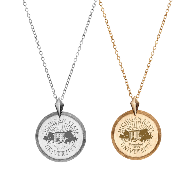A collection of a sterling silver and gold coin necklaces, each with the Michigan State University seal in the middle of the coin medallion.