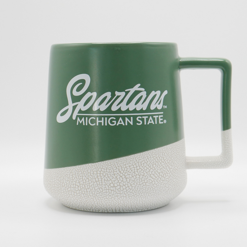 A green and ceramic printed coffee mug with "Spartans: Michigan State" written in white on the side in cursive and all caps print. 