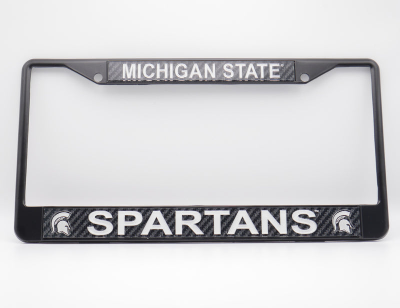 A black license plate frame with the words "Michigan State" at the top of the frame in white, and the word "Spartans" at the bottom of the frame in white. On both sides of the word "Spartans" is a white MSU spartan helmet logo. 