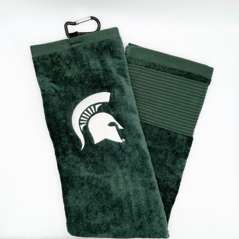 A dark green golf towel with a black clip at the top to attach to golf bags. On the towel is a white MSU spartan helmet logo. 