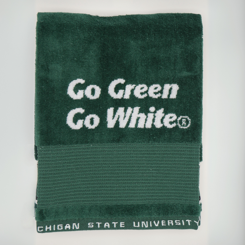 A back portion of a dark green golf towel. In the middle of the back portion are the words "Go Green Go White" written in italic style font. 