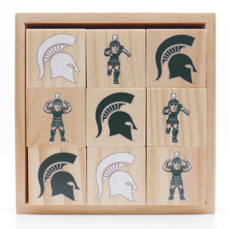 A set of nine wooden play blocks stacked 3 by 3 inside a wooden box. The blocks are showing various icons of Sparty and the MSU spartan helmet logo. 