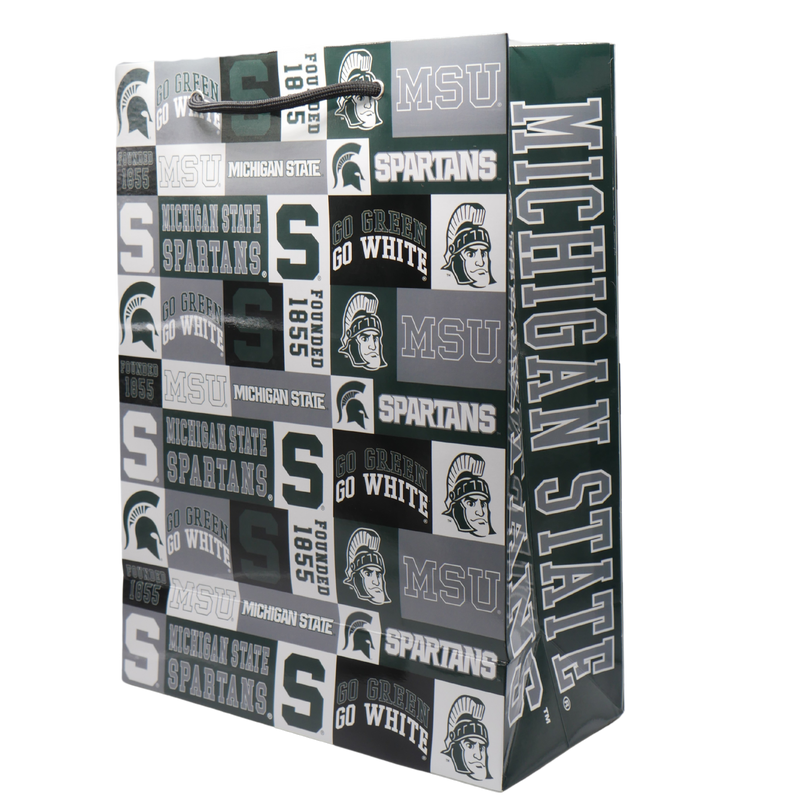 A Michigan State University themed gift bag with various MSU icons, including a block S, MSU spartan helmet, and Sparty illustration printed in green, gray, white, and black. On the side of the bag Michigan State Spartans is written in gray block letters outlined by white. 