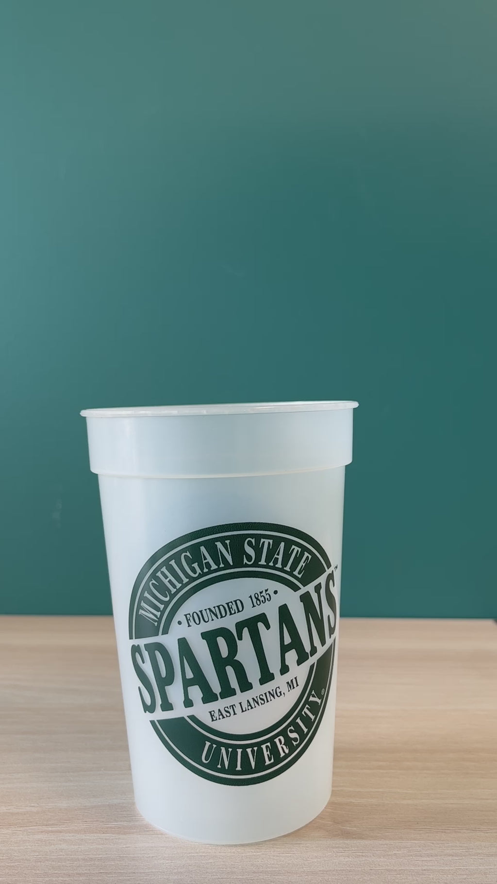 Water pouring into a Michigan State Mood cup, which changes colors when cold liquids are added.