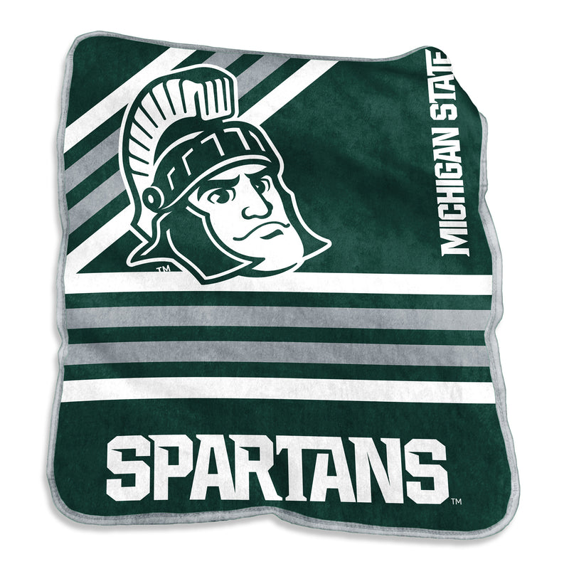A green throw blanket with white and grey lines that go across the blanket horizontally and diagonally. In the middle of the blanket is an illustration of Sparty's head, while the right side has Michigan State written, and Spartans written in all caps on the bottom. 