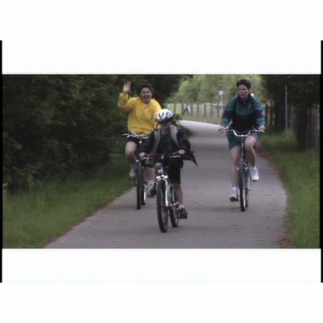 Screenshot from the Making the Connection: Rail-Trails in Michigan Today DVD of a family riding their bicycles