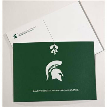 Forest green postcard with a white Spartan helmet underneath outlined mistletoe. Underneath the lemt text reads Healthy holidays from head to mistletoe. The back of the postcard is white with the College of Human Medicine signature logo