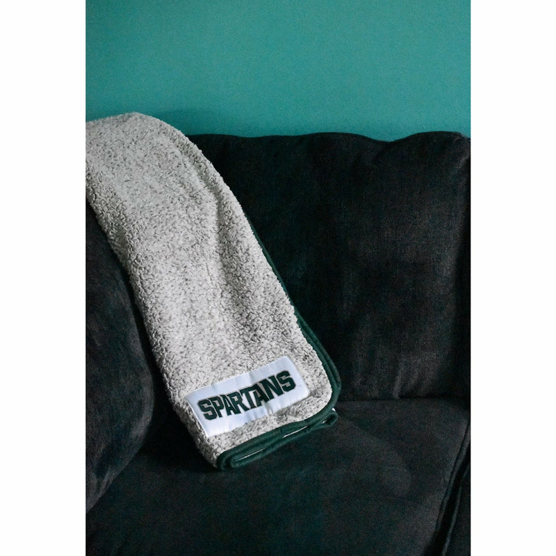 Sherpa blanket folded over the corner of a charcoal couch