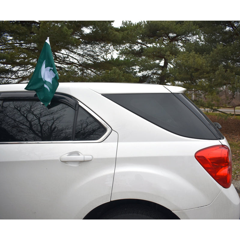 Rear half of a white SUV with the Spartan helmet car flag affixed to the rear driver side window.