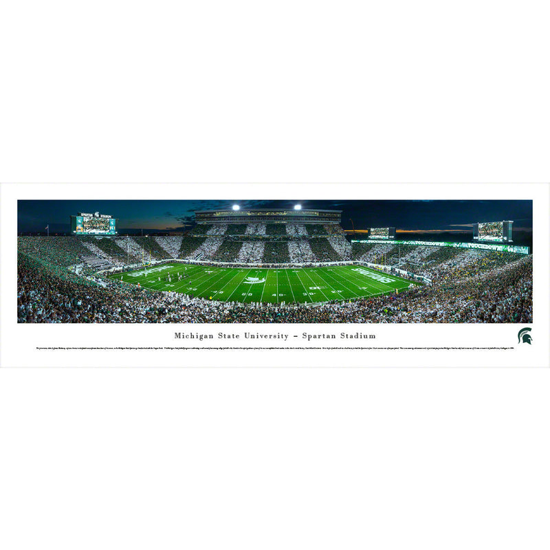 A panoramic view of a filled Spartan Stadium at night. The crowd in the stands of the stadium have groups alternating wearing green and white.