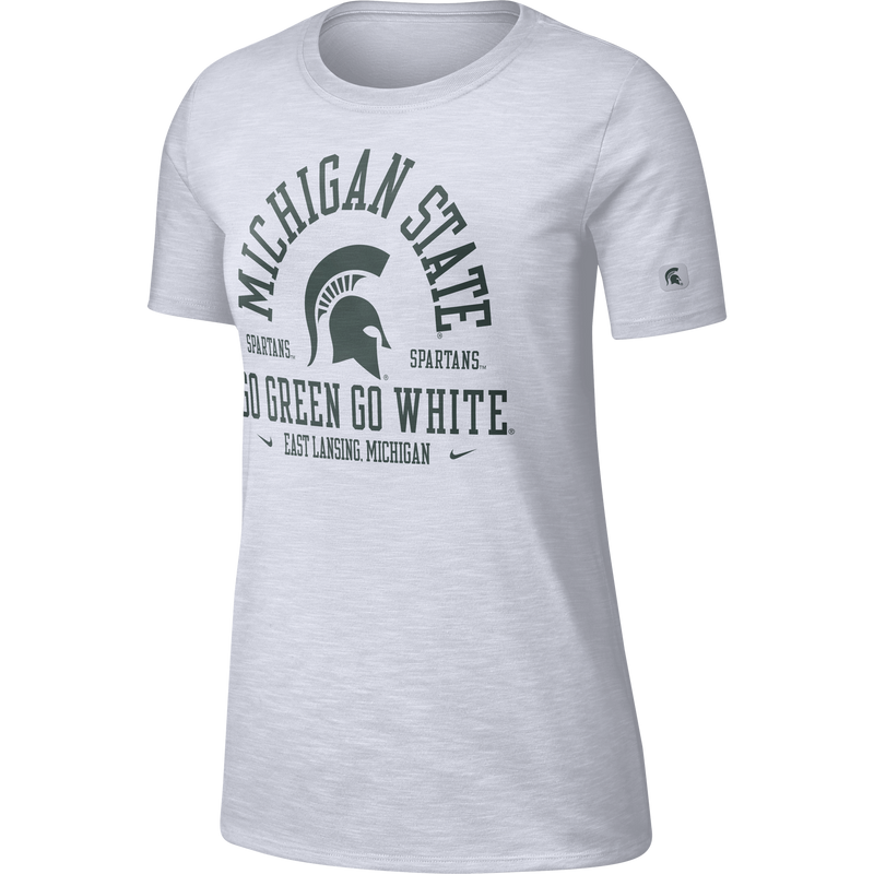 White crewneck t-shirt with short sleeves. On the center chest is arched text reading Michigan State over a Spartan helmet. flanked by the word Spartans on both sides. Below that is text reading Go Green, Go white above a line reading East Lansing Michigan, which is flanked by a Nike checkmark on either side. All graphics are in green.