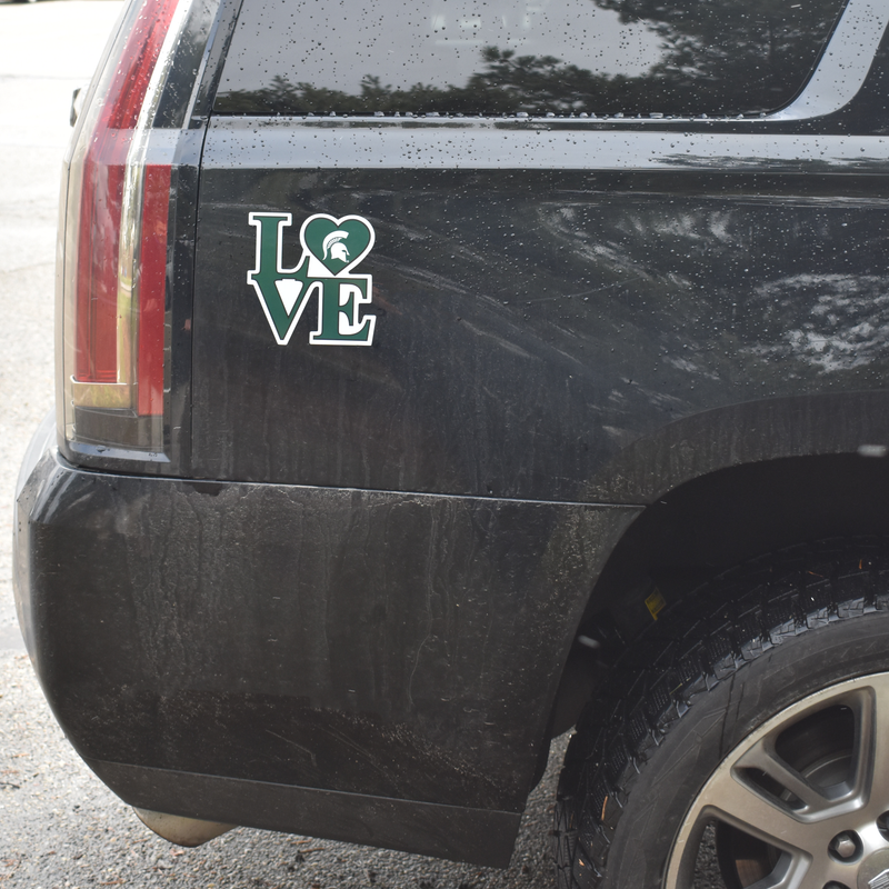 A magnetic Spartan Love decal is affixed to the rear passenger side of a black SUV.