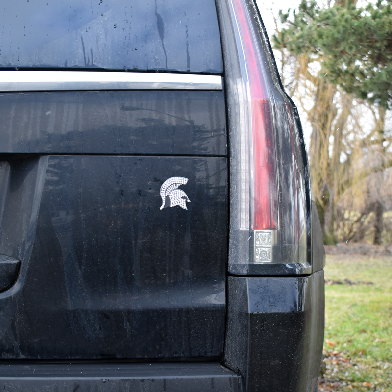 3D chrome bedazzled Spartan helmet on the tailgate of a black SUV
