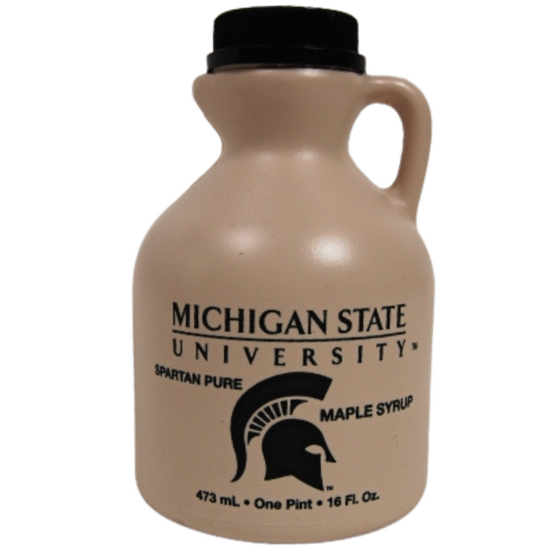 Tan plastic bottle with a small handle near the top. Black printing includes the Michigan State University wordmark, a Spartan helmet, and text reading "Spartan Pure Maple Syrup, 473 milliliters, 1 pint, 16 fluid ounces"