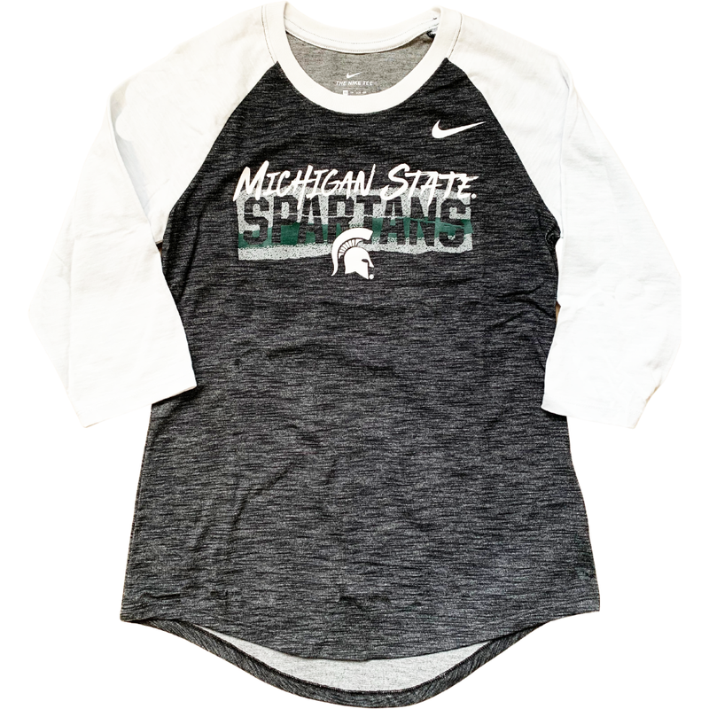 Charcoal heather gray crewneck t-shirt with white raglan-style three-quarter length sleeves. On the left chest is a Nike swoosh, and on the center chest is white text reading Michigan State over a green and white rectangle with Spartans cut out. Below that is a white Spartan helmet.